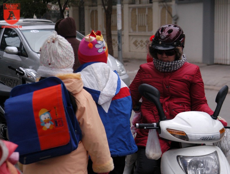 Người Hà Nội mặc thêm áo mưa ra đường vì lạnh